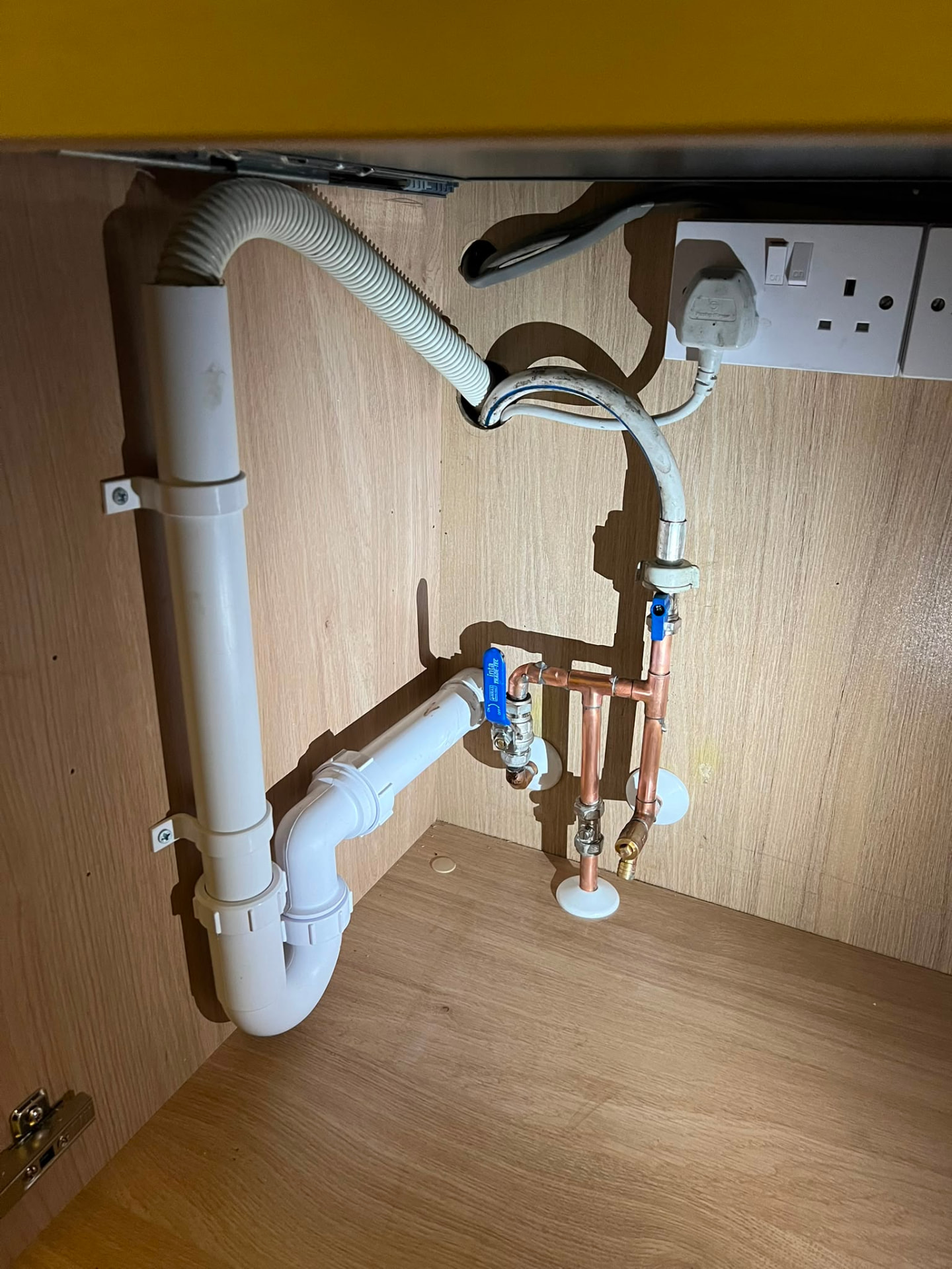 Neat under-sink copper and waste pipework after a kitchen plumbing installation, fitted by Gas Safe registered engineers in Essex