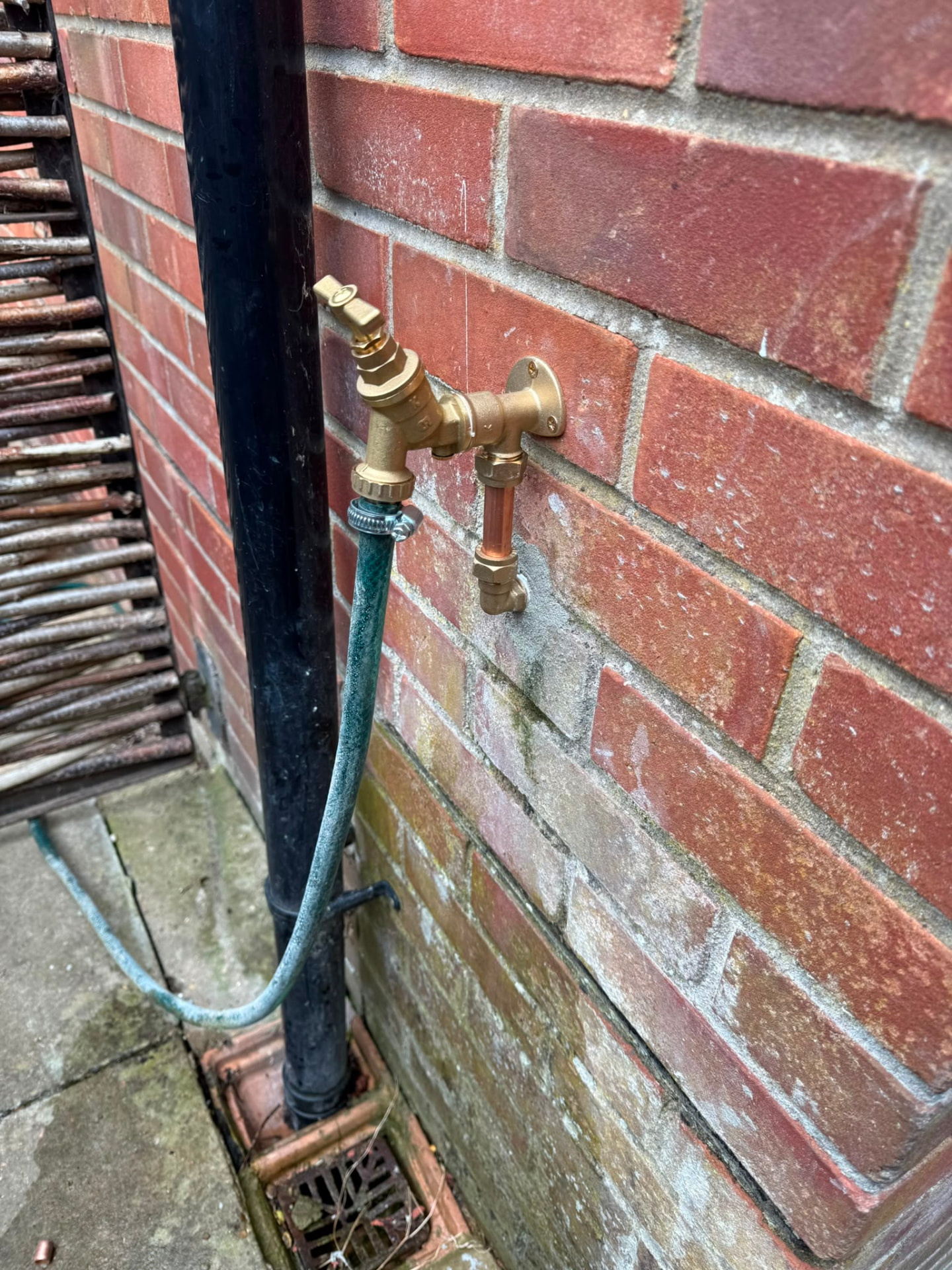 Outside tap installation on a brick wall with backflow protection fitted, fitted by Gas Safe registered engineers in Essex