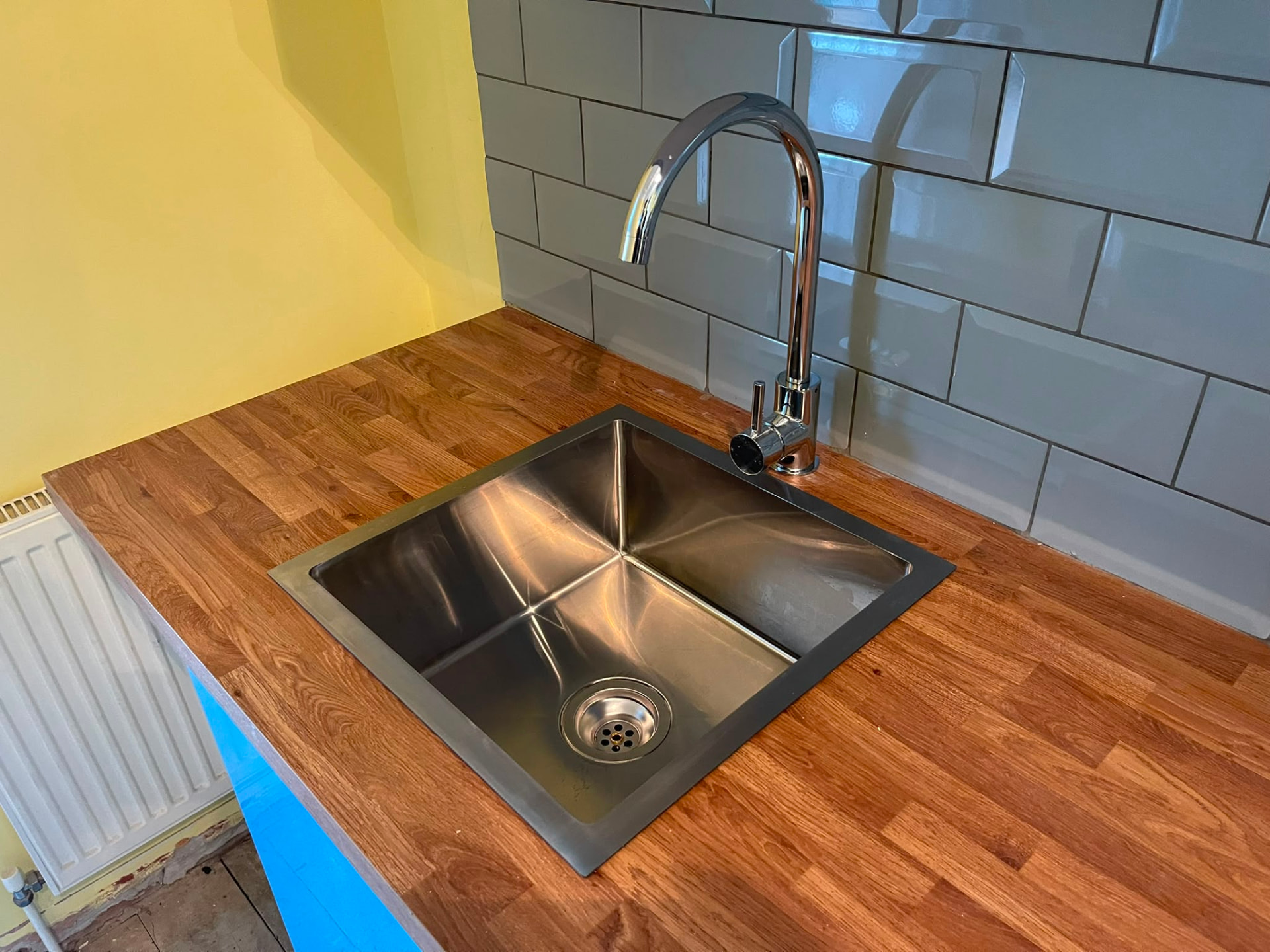 Stainless steel undermount kitchen sink and mixer tap installation in a wooden worktop, fitted by Gas Safe registered engineers in Essex